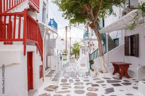 Fototapeta Naklejka Na Ścianę i Meble -  Mykonos town streetview with tree and red banisters, Mykonos town, Greece