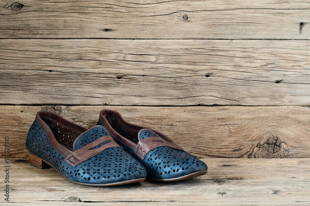 Naklejka premium Women's shoes on a wooden background closeup