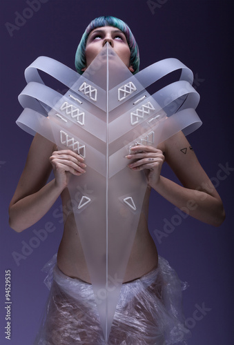 Young, thin, pale girl with tirquoise blue-purple hair ,with pageboy hairstyle, purple make up, in futuristic ,plastic ,white ,transparent costume  photo