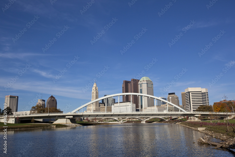 Columbus Ohio along the Scioto river with the Main Street Bridge in the foreground.