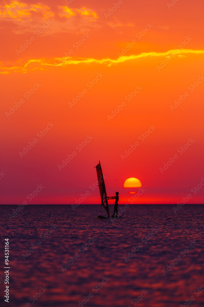 windsurfer silhouette against sun
