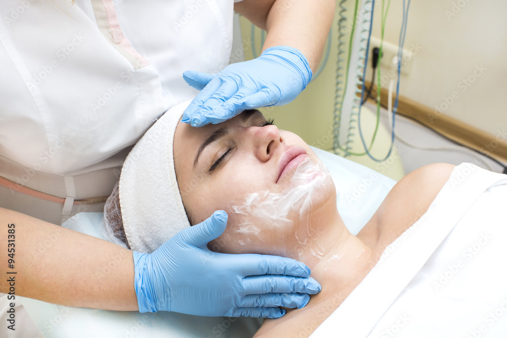 Naklejka premium woman passes treatment mask facial at the beauty salon