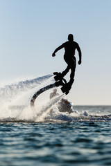 Acrylglasbilder Wasser Motorsport Flyboard-Fahrer als Silhouette  © Mrakor