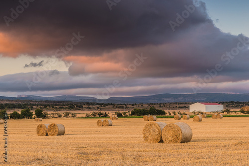 Straw bales in the field at sunset with dramatic sky