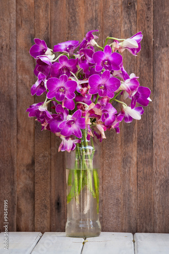 Beautiful bouquet orchids flower on wooden table