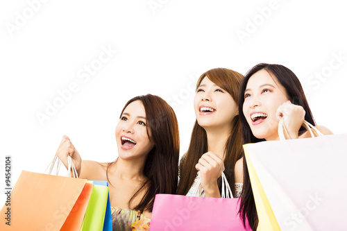 Group of happy young woman with shopping bags looking up