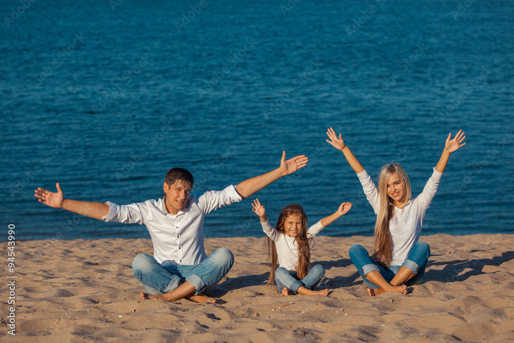 Family at the beach. lotus posture. hands up, happiness, jeans. Family at the beach. lotus posture. hands up, happiness, jeans.