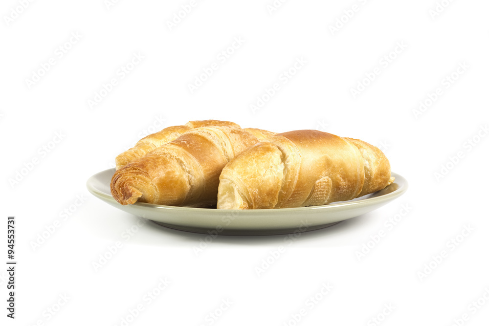 Fresh croissants on green plate isolated on white