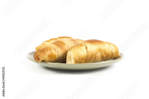 Fresh croissants on green plate isolated on white