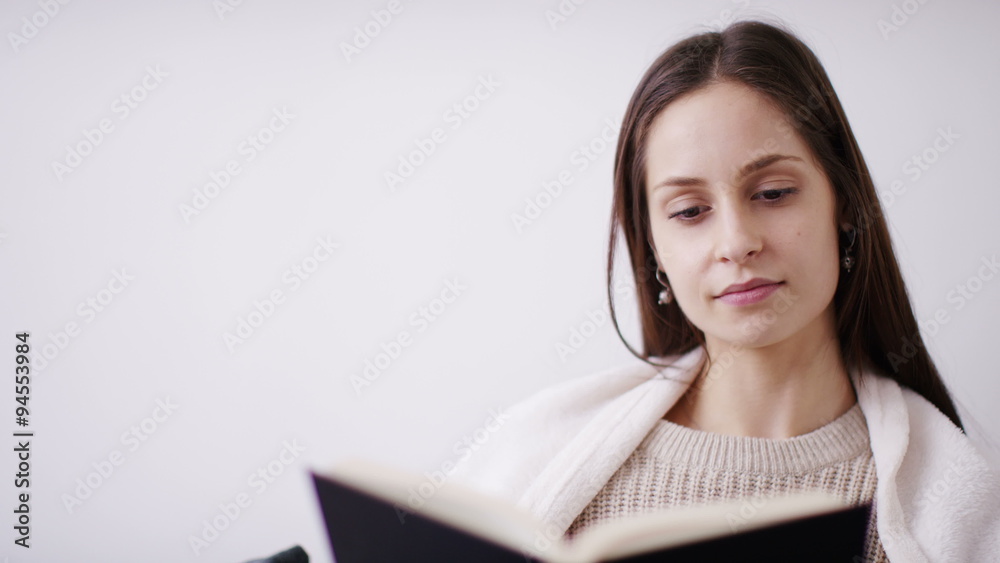 4K Portrait of an attractive young woman reading a book and then smiling to camera, in slow motion 4K Portrait of an attractive young woman reading a book and then smiling to camera, in slow motion