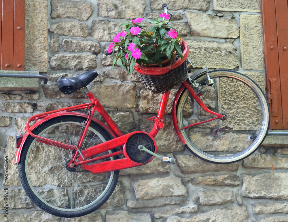 bicycle attached to a stone wall between the windows