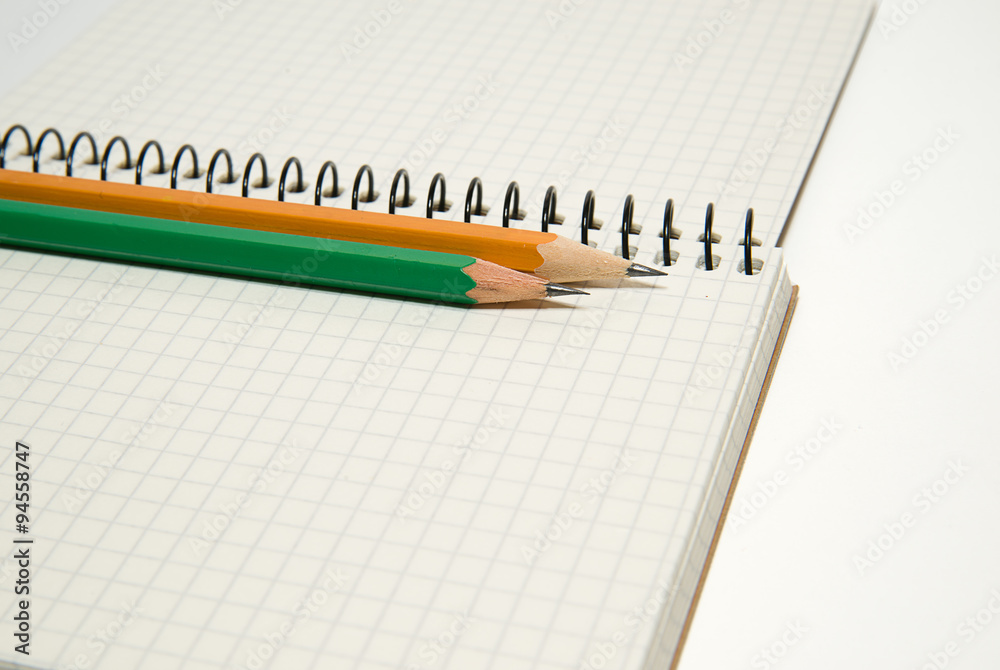 Opened notebook and pencils on over white Opened notebook and pencils on over white