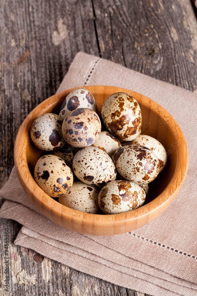 quail eggs in a wooden bowl on a gray background quail eggs in a wooden bowl on a gray background