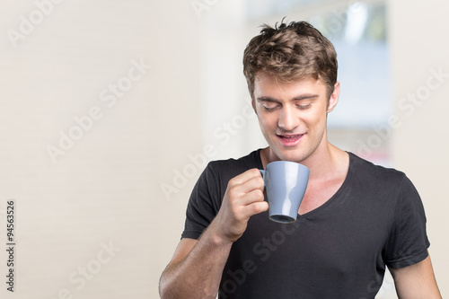 Young man holding warm cup of tea/coffee