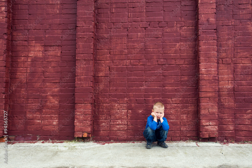 Depressed child near brick wall Depressed child near brick wall