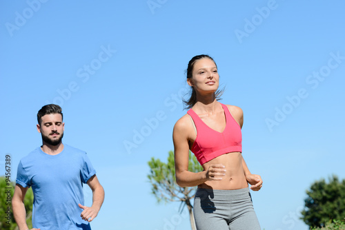 young healthy couple running outdoor in summer during a fitness exercise