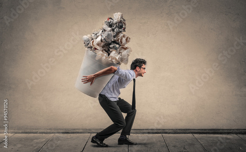 Foto Employee carrying a huge trash bin