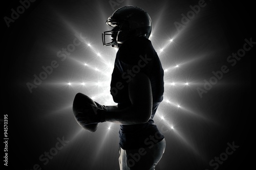 Composite image of side view of sportsman holding football