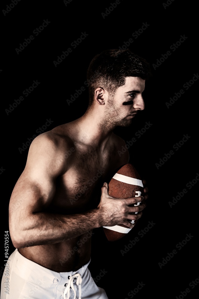 Composite image of shirtless rugby player holding the ball Composite image of shirtless rugby player holding the ball