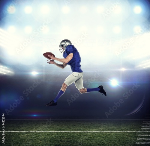 American football player running while catching ball
