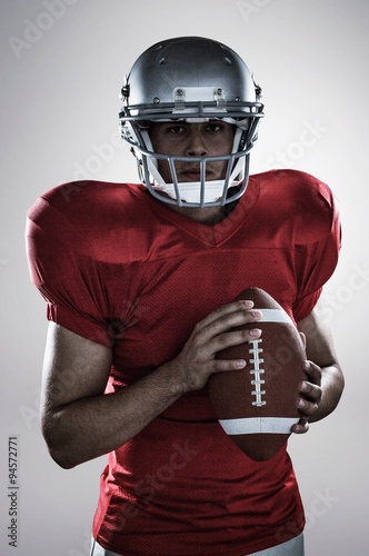 Portrait of confident sportsman with american football