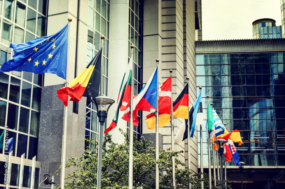Waving flags in front of European Parliament building in Brussel - obrazy, fototapety, plakaty 
