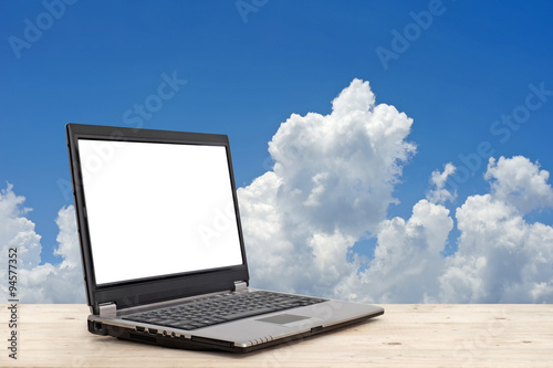 laptop with blank screen on wooden table with beautiful sky back © leisuretime70