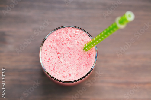 A glass of fresh watermelon smoothie on wooden background