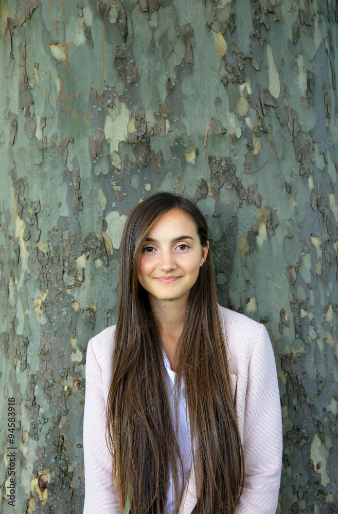 Portrait of beautiful girl on background of the tree