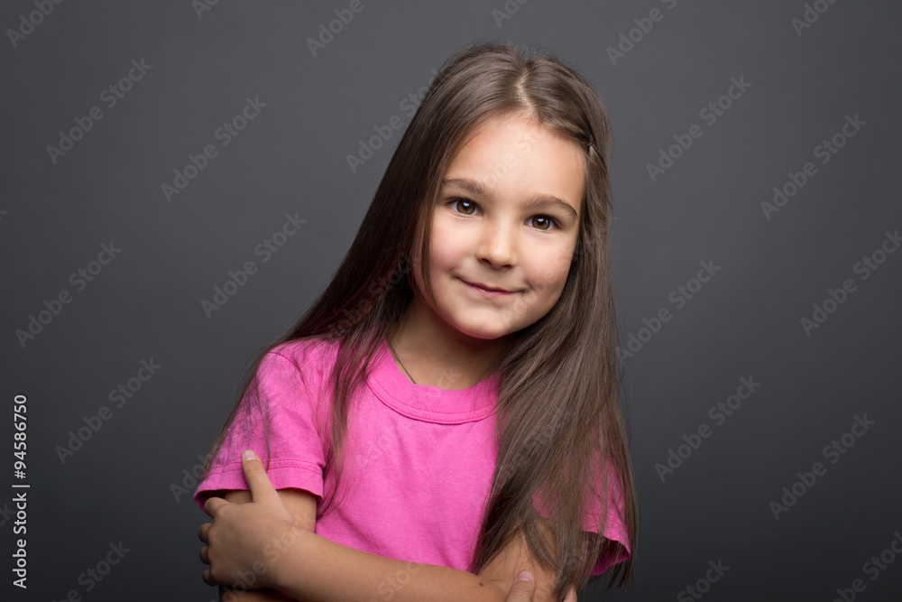 Fototapeta premium Portrait of a little girl on a gray background