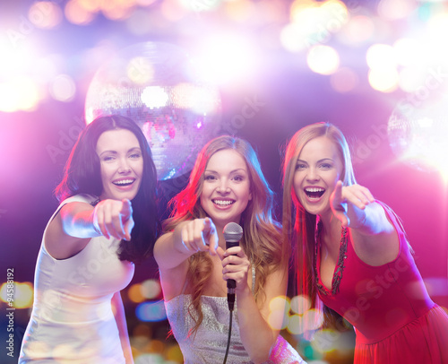 happy women singing karaoke and dancing
