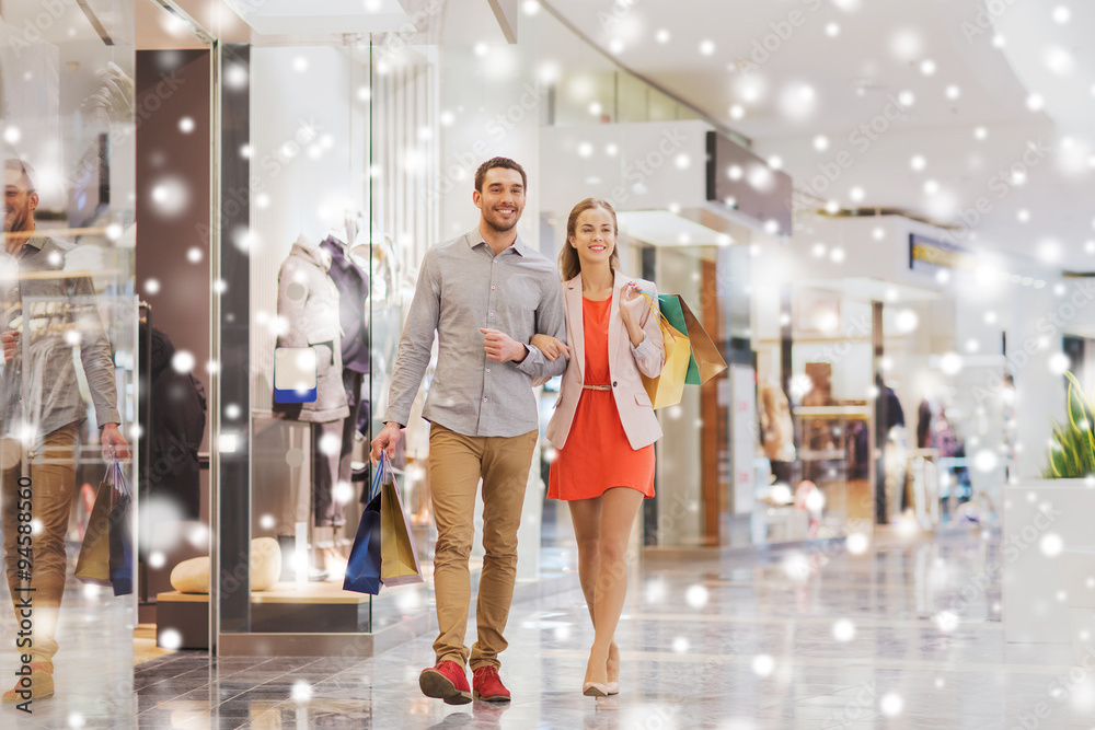 happy young couple with shopping bags in mall