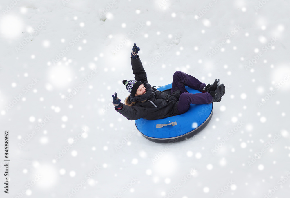 happy young man sliding down on snow tube