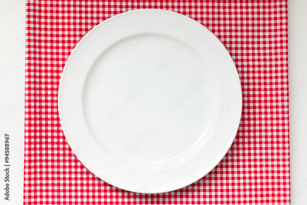 white dish or plate on red classic checkered tablecloth texture on white table with copy space for advertise food product and other white dish or plate on red classic checkered tablecloth texture on white table with copy space for advertise food product and other
