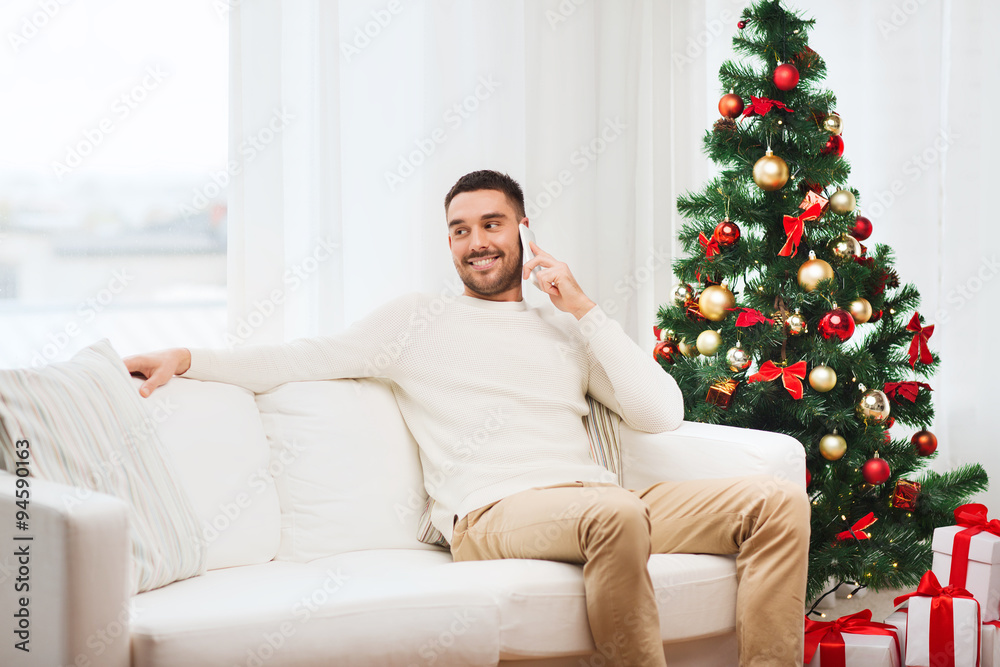 Obraz premium man calling on smartphone at home for christmas