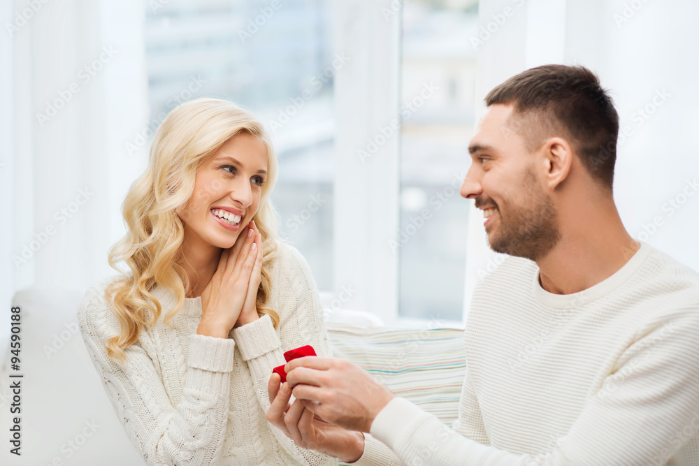 happy man giving engagement ring to woman at home happy man giving engagement ring to woman at home