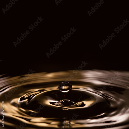 Liquid drops. splashing. gold, black, white waves. Black background