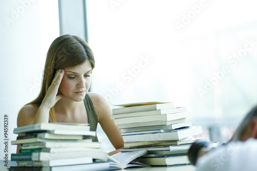 Giovane studentessa prepara una esame in biblioteca