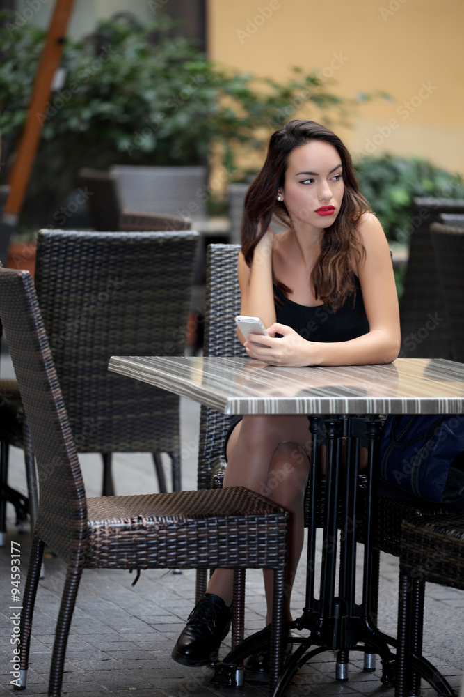 Woman using mobile phone in cafe