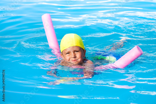 Boy learns swimming alone with pool noodle