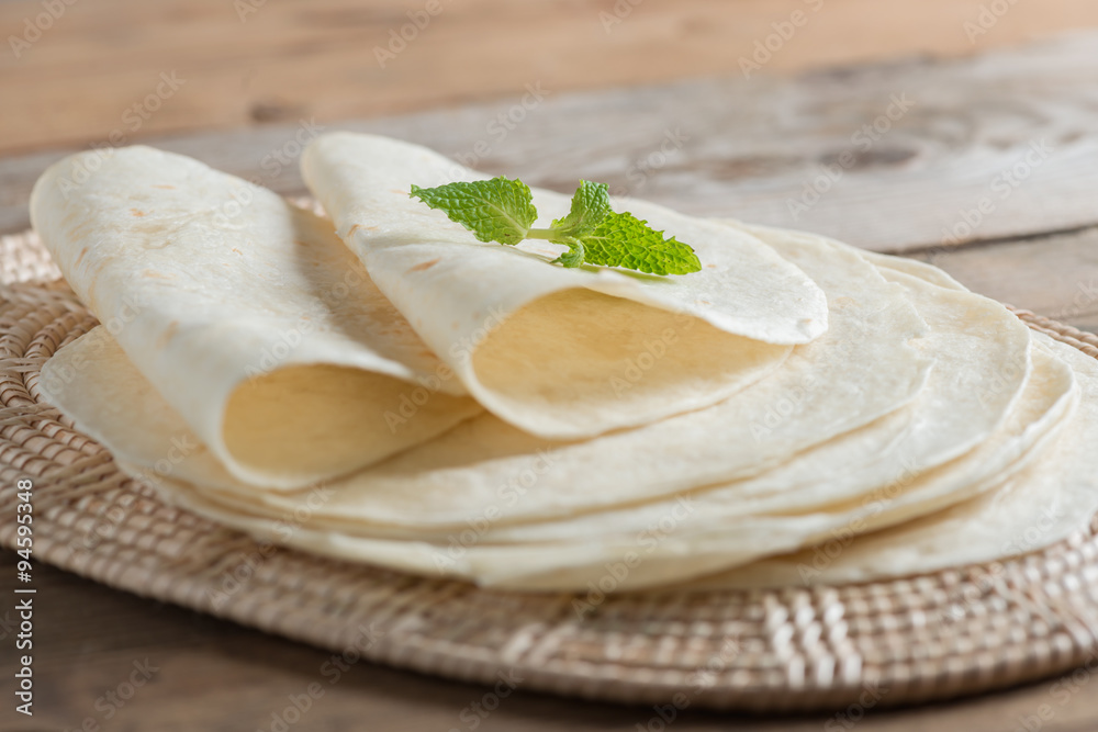 Homemade whole wheat flour tortillas on wooden table.