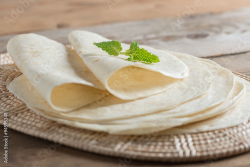 Homemade whole wheat flour tortillas on wooden table.