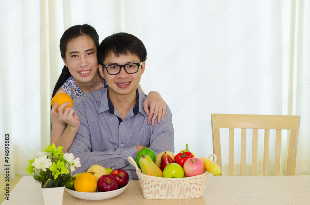 Portrait of young Asian couple with fruits, healthy eating concept