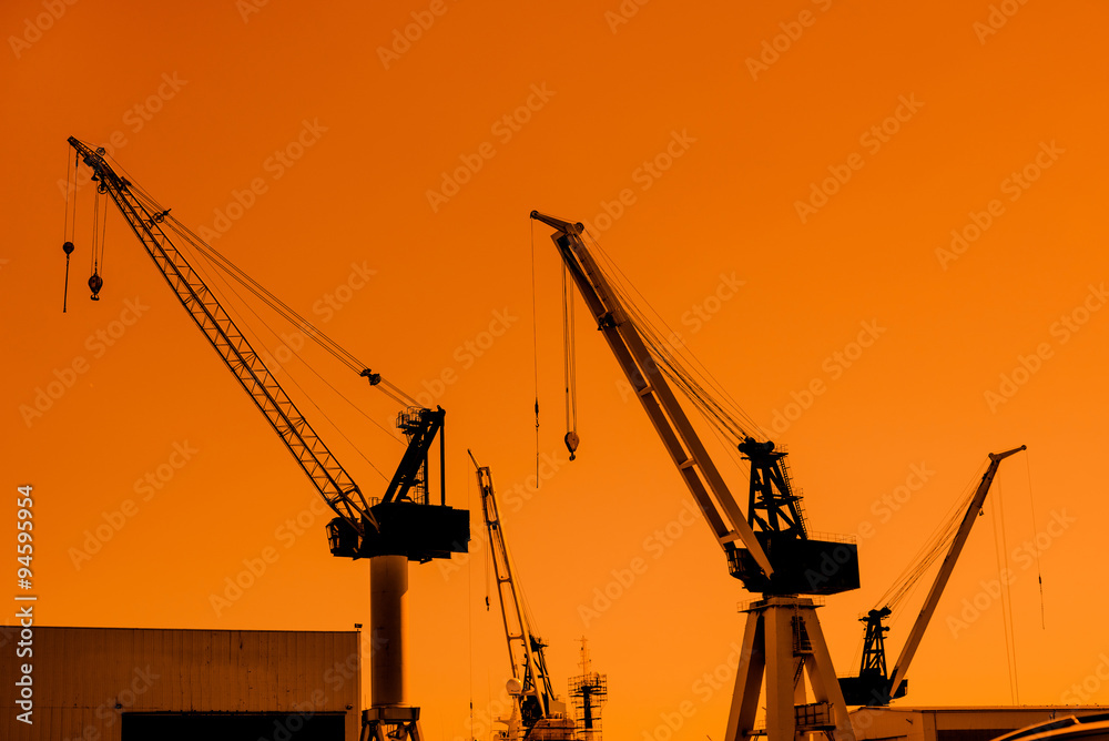 Crane silhouettes at a shipping harbor