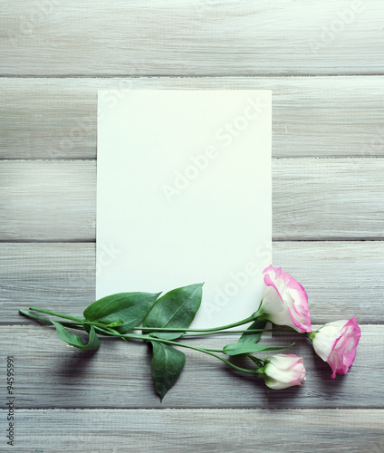 Composition of white sheet and rosy  blossom on grey wooden background, empty space