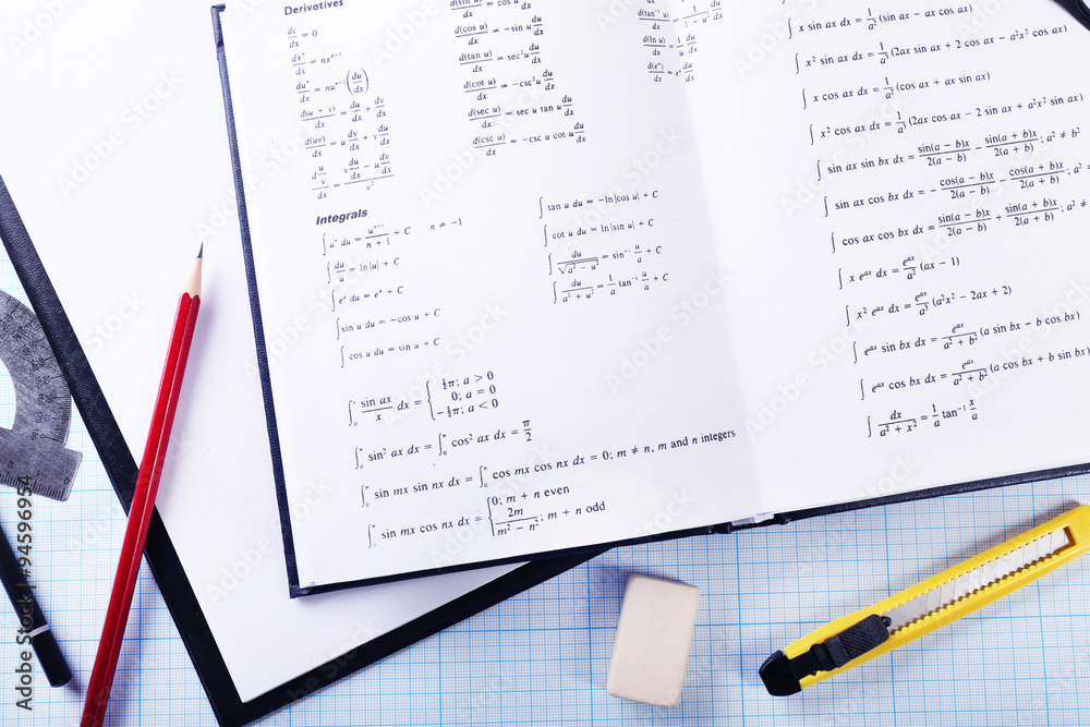 School supplies and textbook on mathematics close up School supplies and textbook on mathematics close up