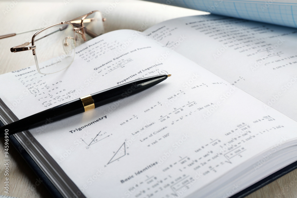 School supplies and textbook on mathematics close up School supplies and textbook on mathematics close up