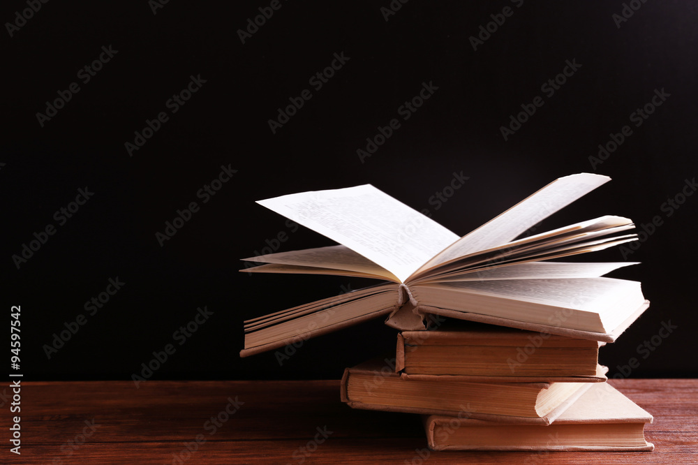 Old books on wooden table against black background Old books on wooden table against black background