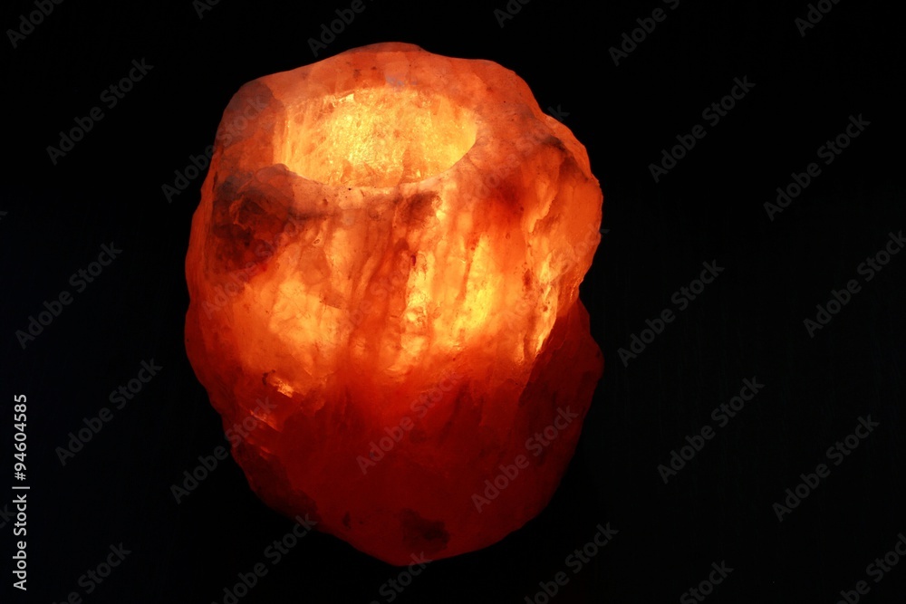 Burning and glowing orange salt lamp on a black background Burning and glowing orange salt lamp on a black background