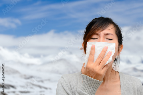 Asian woman catch a cold with snow background. photo